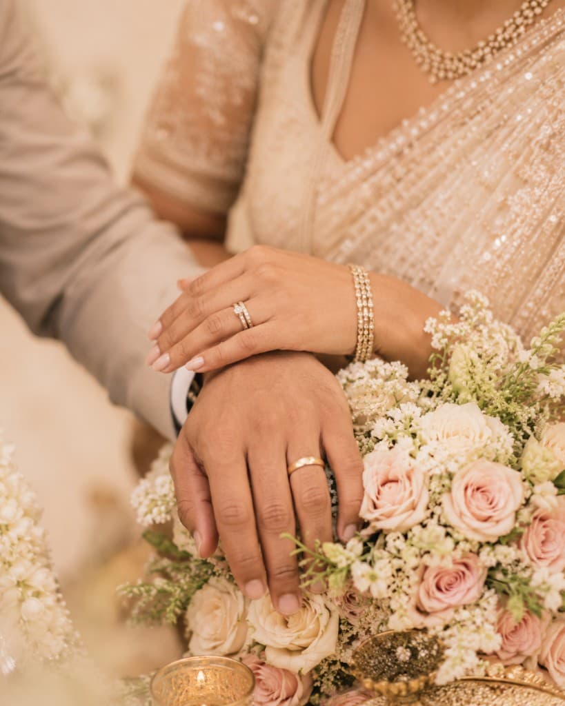 Joined hands resting on pink roses